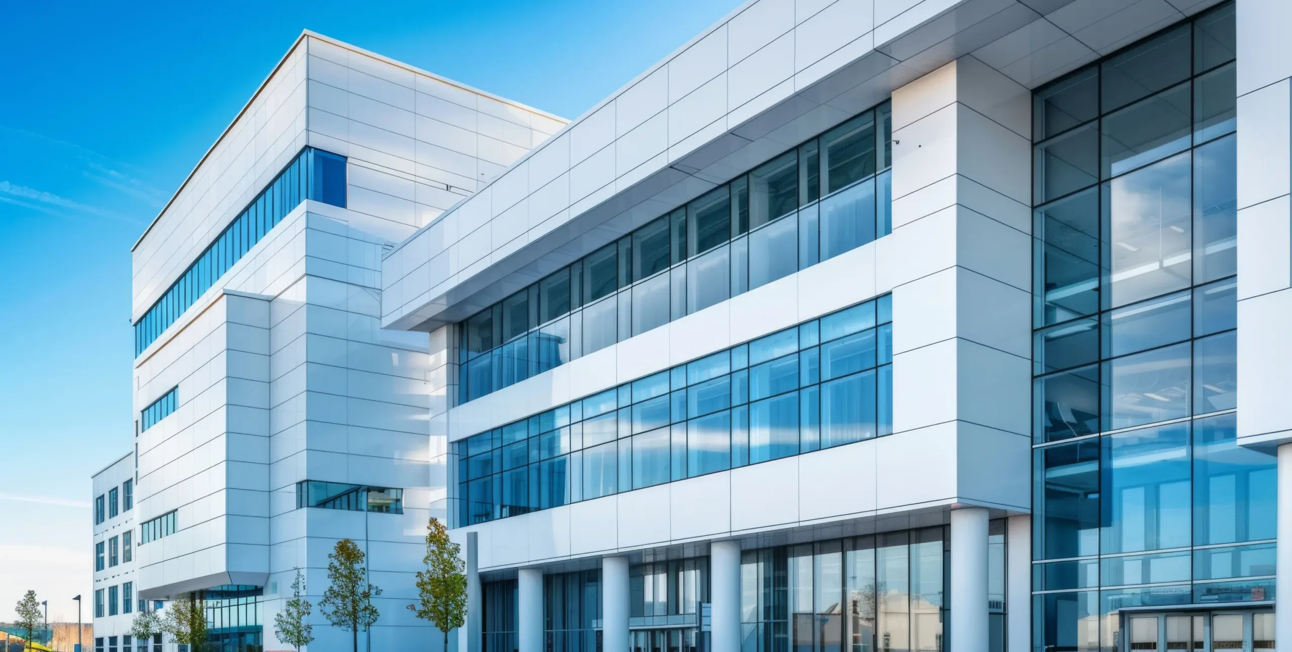 Home Modern office building with large glass windows and white exterior panels under a clear blue sky, with a few small trees in front—the ideal location for leading San Jose IRS whistleblower lawyers or Silicon Valley CFTC whistleblower attorneys providing expert legal counsel.