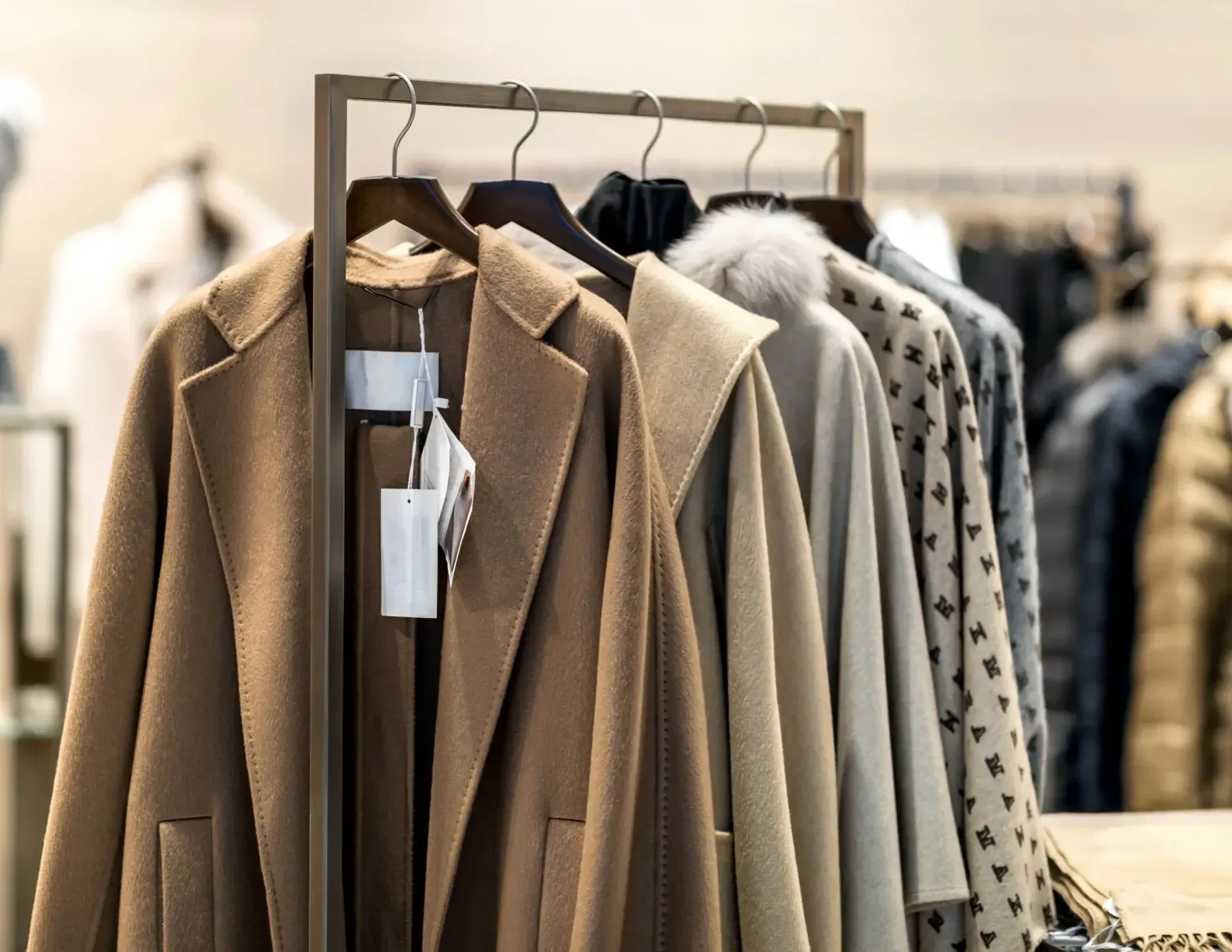 Home A clothing rack displays several coats and jackets in neutral tones, including brown, beige, and patterned styles, on wooden hangers in a retail store—much like meticulous evidence laid out by a New York City tax whistleblower lawyer when building a case.