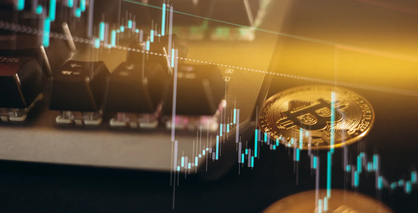 Bitcoin coins and a keyboard are shown with overlaid financial candlestick graphs, representing cryptocurrency trading and market analysis—a dynamic world where vigilance is crucial, much like the role of a New York Medicare whistleblower in monitoring financial integrity.