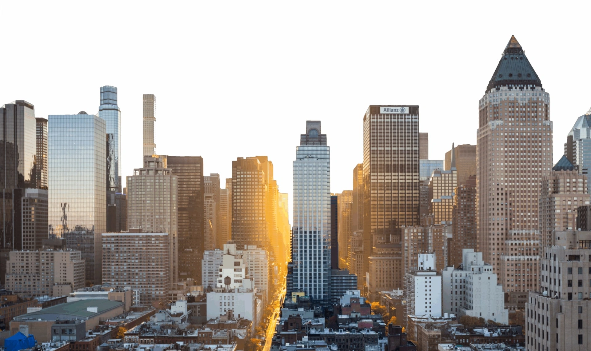 City skyline with tall office buildings under a clear sky; sunlight shines through the gap between skyscrapers, illuminating the street below—an atmosphere reminiscent of a bustling metropolis where a San Francisco healthcare fraud lawyer might work to protect client interests and uphold justice.